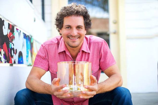 David Kennet holding a crystal singing bowl that he uses in his soul sounding sessions.